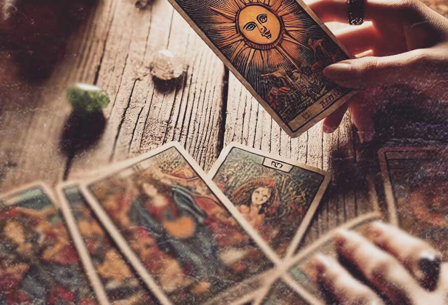 A fortune teller lays out cards across a table