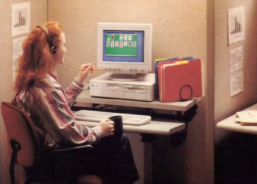 Office worker playing Microsoft Solitaire on a Windows 3.0 computer in the 1990s