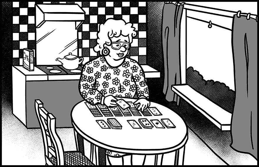 Relaxed woman playing Solitaire at a kitchen table, looking calm in a cozy home setting.